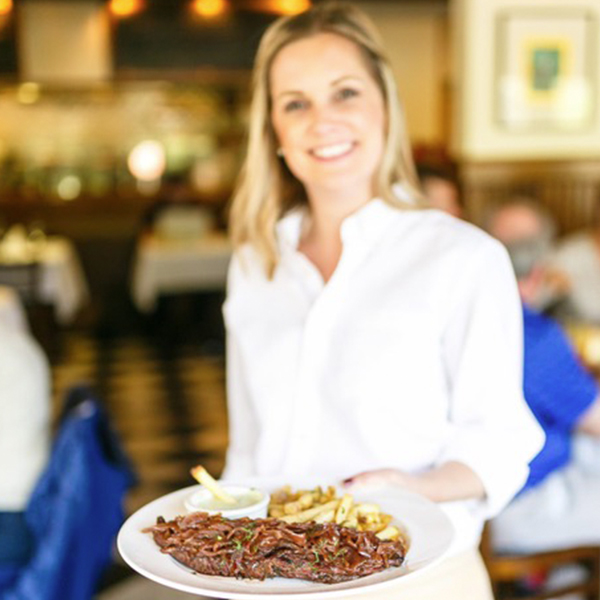 Server carrying food at Mustards Grill